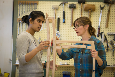 Eva Haviarova holds a chair while talking to a student