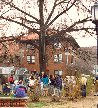 Harvey Holt helps a child climb a tree at Springfest in 1996
