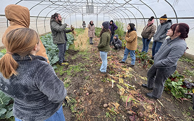 The Indiana LSLA class talks with an agricultural professional in a greenhouse.