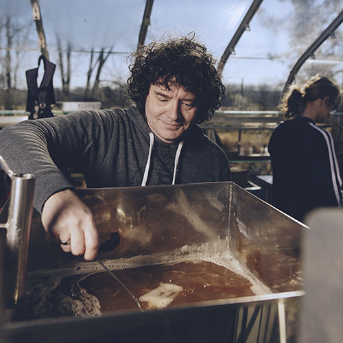 A maple syrup producer looks out over his processing equipment.