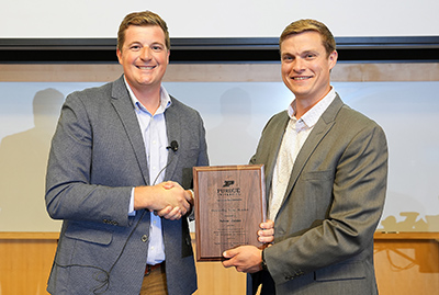 Dr. Adam Janke is presented his 2023 Outstanding Young Alumnus Award by Jarred Brooke