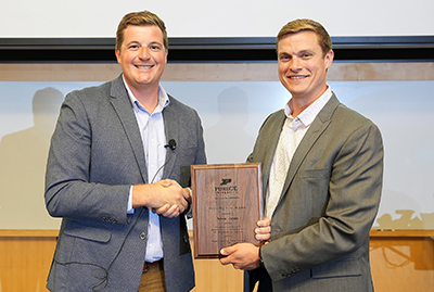 Jarred Brooke presents Adam Janke with his 2023 FNR Outstanding Young Alumnus Award.