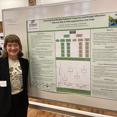 Alyssa Johnson stands next to her research poster