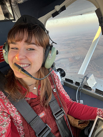 Emma Johnson wears a headset while on an aerial survey for deer