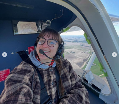Emma Johnson shown in the air in a light-sport aircraft. 