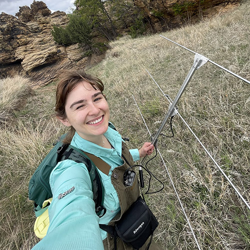 Emma Johnson holds an antenna as she conducts a radio telemetry survey on pronghorns in Oklahoma.