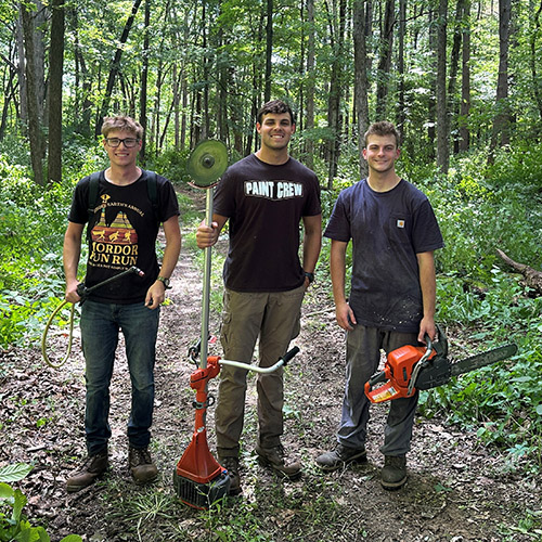Senior Isaac Johnson sprays invasive species, conducts midstory control and stands next to a tree he felled during his summer as a Forestry and Natural Resources intern. 