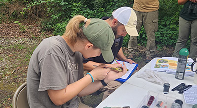 Hannah Kaluf and Dr. Patrick Ruhl participate in bird banding.