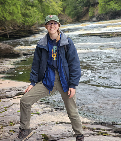 Hannah Kaluf stands in front of a waterfall.