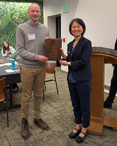 Dr. Ken Kellner is presented the Outstanding Young Alumni plaque by Dr. Zhao Ma.