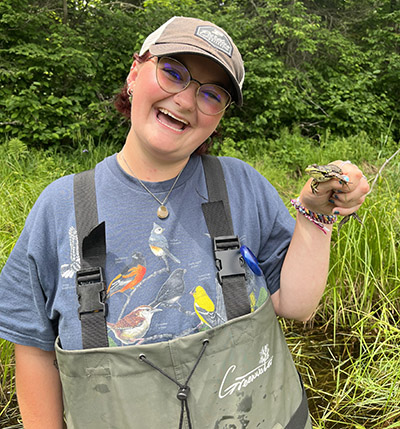 Kira King holds a frog. 