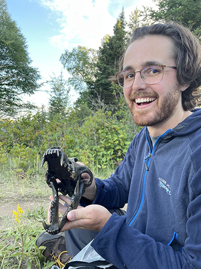 Junior wildlife major Evan Kinnevan pictured with a wolf skull on Isle Royale. 