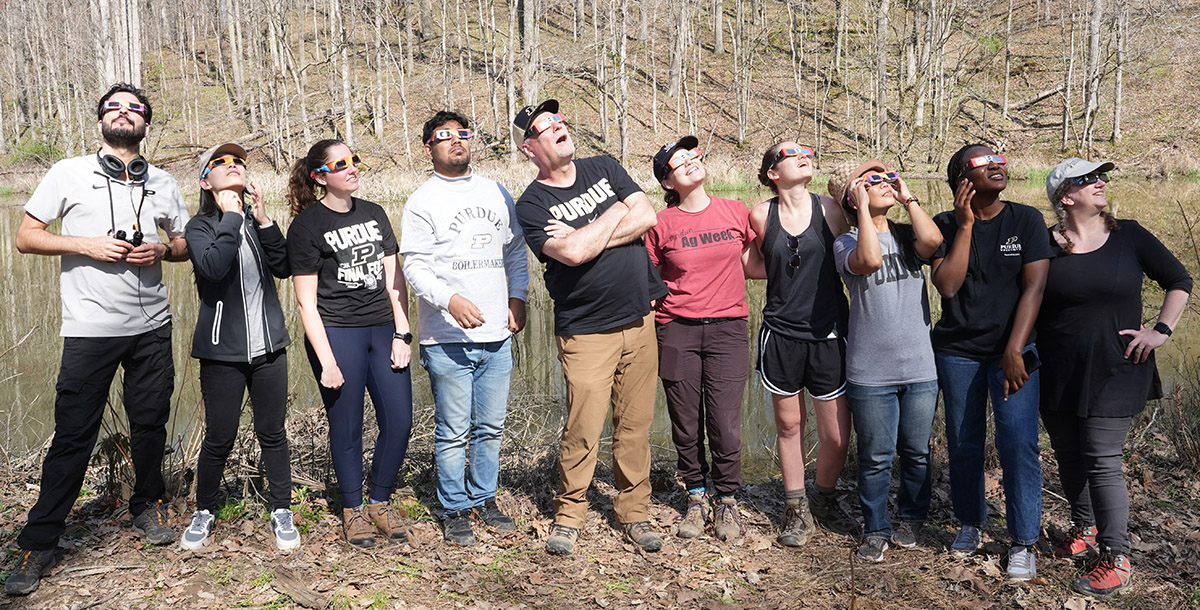 Dr. Christina Mediastika stands amidst members of the Center for Global Soundscapes lab, observing the solar eclipse in April 2024