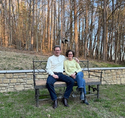 Vince and Jenn Milnes sit in front of the forest land on their property in Brown County, Indiana