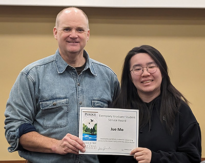 PhD student Jue Mo (right) receives her Exemplary Graduate Student Award certificate from Dr. Reuben Goforth.