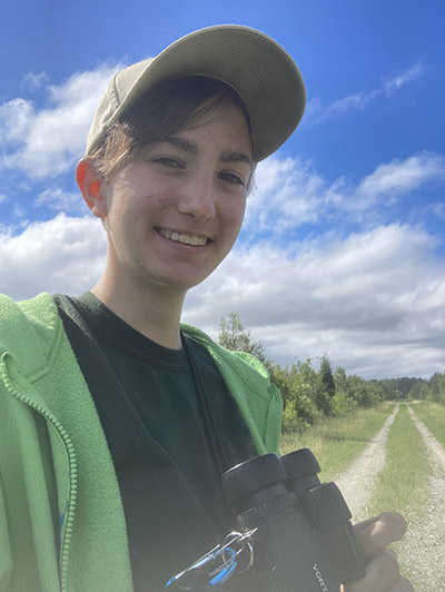 Lydia Pultorak holds a pair of binoculars while conducting a bird survey in North Carolina