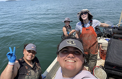 Lara with her crew: farm manager Amy Gaiero, PhD student Taja Harper and intern Candance Power on the boat