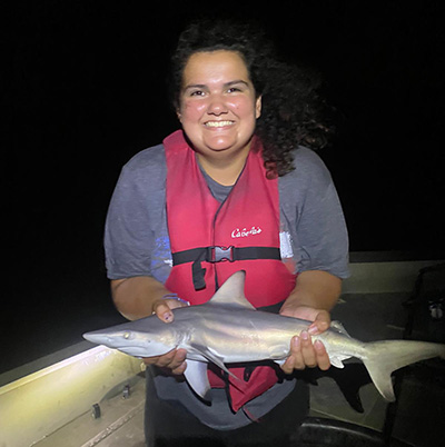 Lara holds a black-tipped shark she caught while night fishing at Marine Biology Practicum