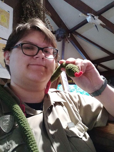 Ren Schiller with a crocheted snake around their shoulders