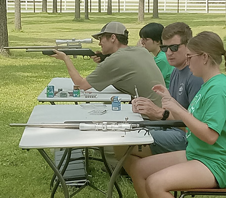 Jackson Schwartz holds a gun during his Hunting for Conservation course alongside Purdue extension specialist Jarred Brooke and a fellow student.