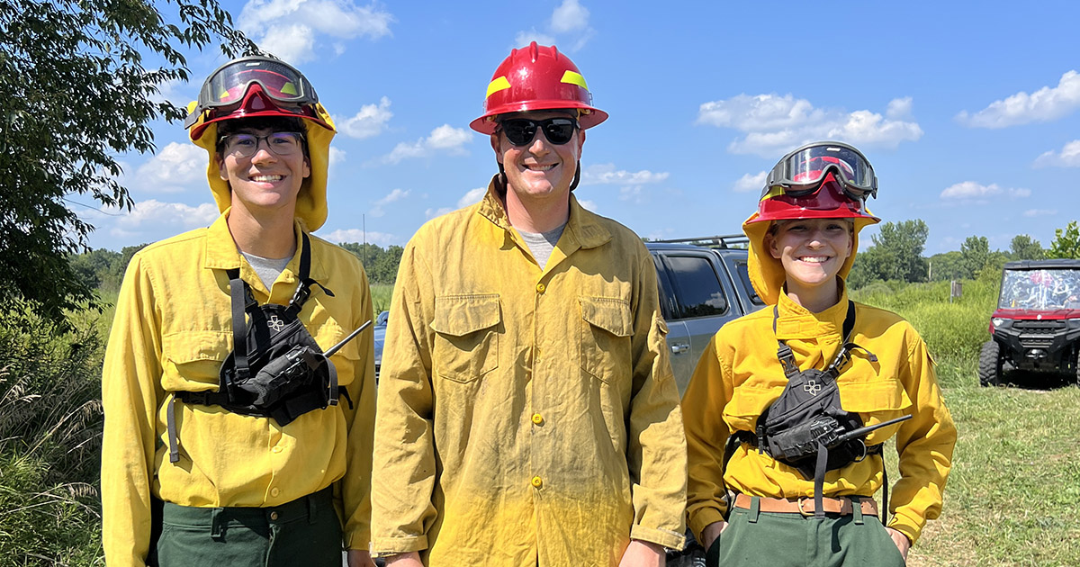 Jackson Schwartz with extension specialist Jarred Brooke and another student at a prescribed burn.