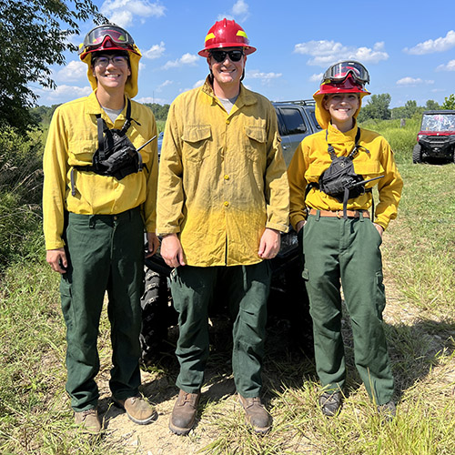 Jackson Schwartz with extension specialist Jarred Brooke and another student at a prescribed burn.