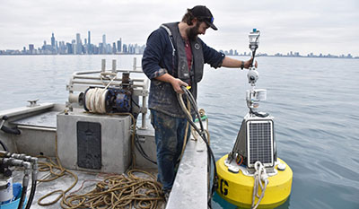 IISG buoy specialist Ben Szczygiel helps Chuoy the Chicago buoy settle into its prime location near Navy Pier where it monitors Lake Michigan water and weather conditions. 
