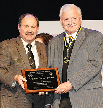 Smith receiving Certificate of Distinction plaque.