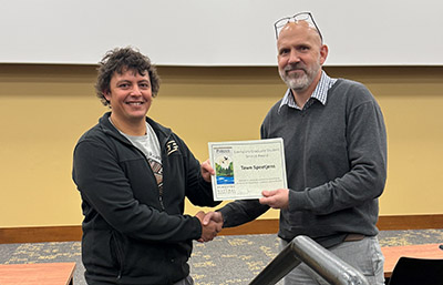 Tawn Speetjens receives a certificate for the Exemplary Graduate Student Award from department head Tomas Höök.