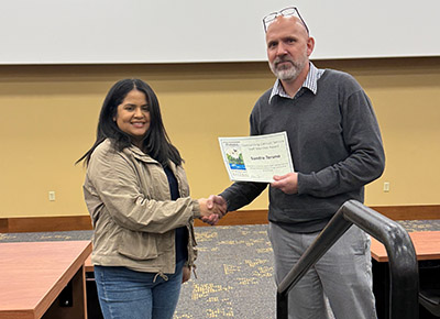Sandra Toruno receives her certificate for the Outstanding Clerical/Service Staff Award from department head Tomas Höök.