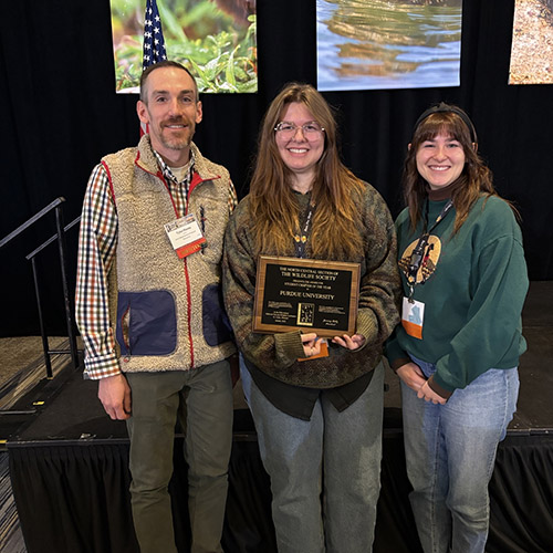 Purdue TWS president Celia Parton and master's student Emma Johnson accept the plaque for North Central Region Student Chapter of the Year at the Midwest Fish and Wildlife Conference.