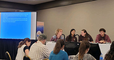 Wilson, Talbot, Dudley and Sickbert sit at a table on stage answering a question during TWS Quiz Bowl 2023