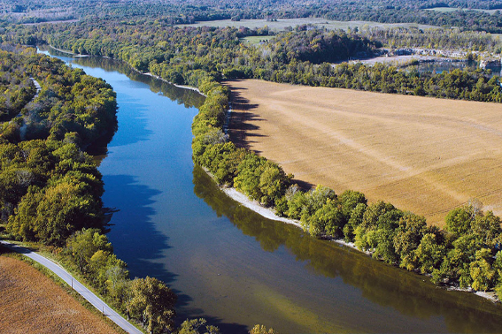Aerial view of waterway lined with trees.