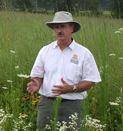 Dean Zimmerman talks while standing in a field