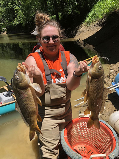 Kirsten Adams holding two fish she caught during her summer internship with IDEM.