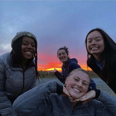 Gabby Dennis with her colleagues in front of a Middleton Island sunset