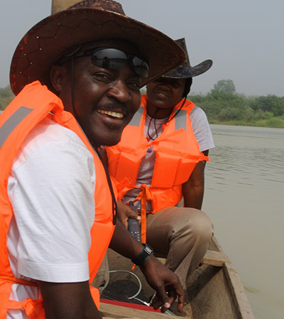 Frimpong with PhD student on Volta Lake in Ghana studying the invasion of genetically improved farmed tilapia into the natural water bodies of Ghana.