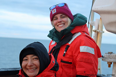 Amanda Herbert (foreground) and Ami Everett onboard the R/V Norseman II. Amanda and Ami are on top of the wheelhouse of the ship to observe groups of Pacific walrus hauled-out on sea ice. Observers assign each animal in a group to an age/sex category according to published criteria.