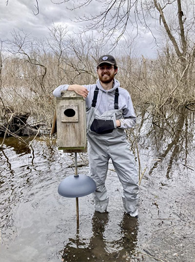Junior wildlife major Evan Kinnevan with a duck box he worked on with the Purdue student chapter of The Wildlife Society.