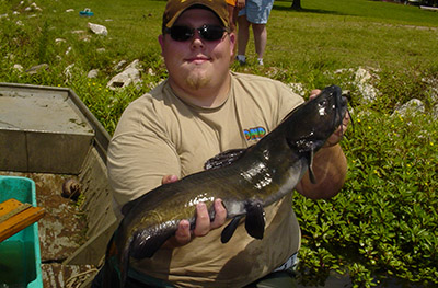 Tom Lang holding a fish while working for the Indiana DNR in 2004