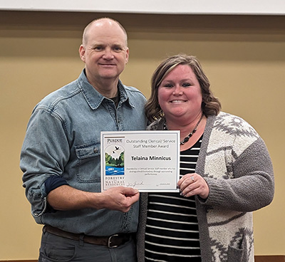 Telaina Minnicus (right) receives her Outstanding Clerical/Service Staff Member Award certificate from Dr. Reuben Goforth
