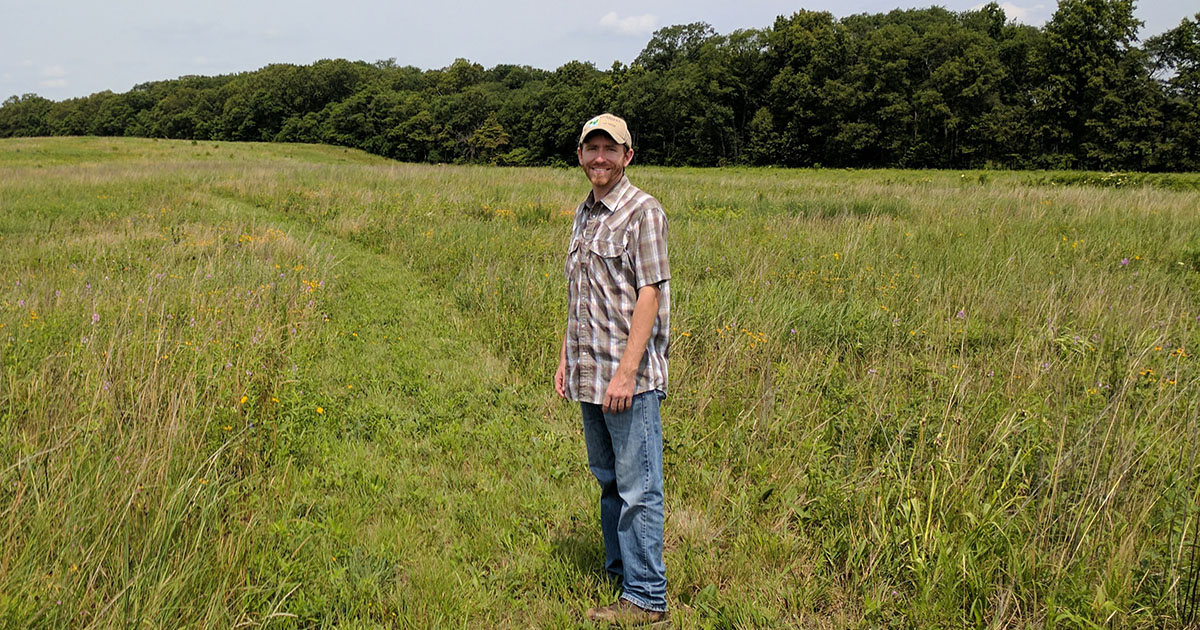 2008 Wildlife alumnus Travis Stoelting stands in a prairie