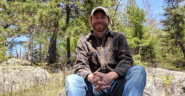2008 Wildlife alumnus Travis Stoelting stands in a prairie