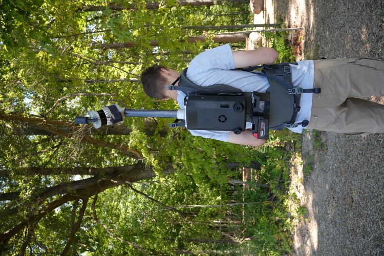 person wearing lidar backpack in wooded park