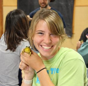 Summer Practicum student holding a frog