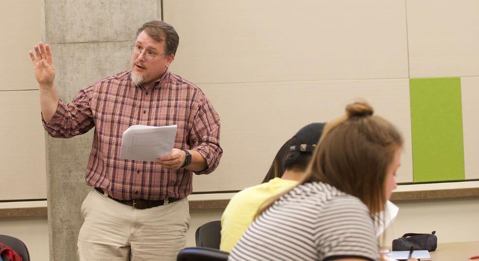 Trevor Stamper teaching a course with a student in the foreground