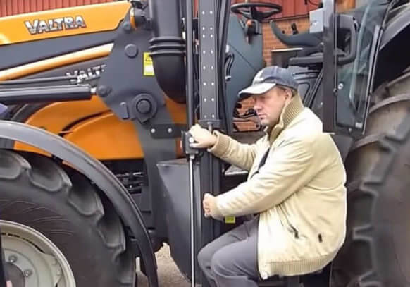 Men speaking in front of a tractor