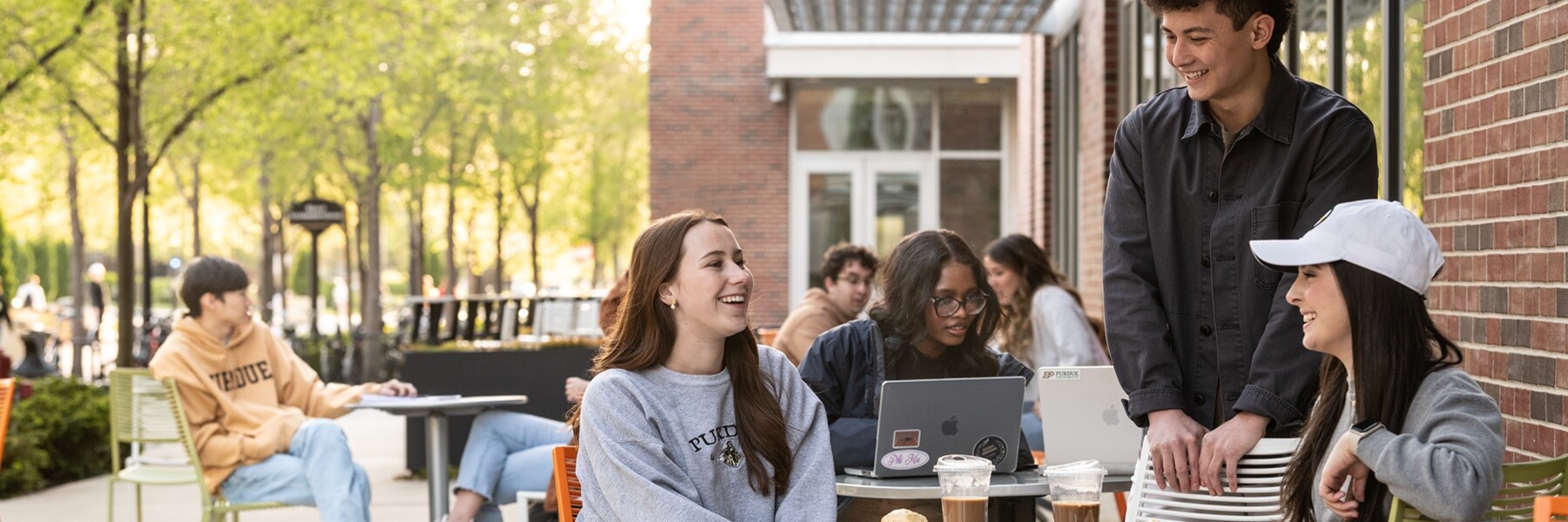 Students outside at tables with laptops