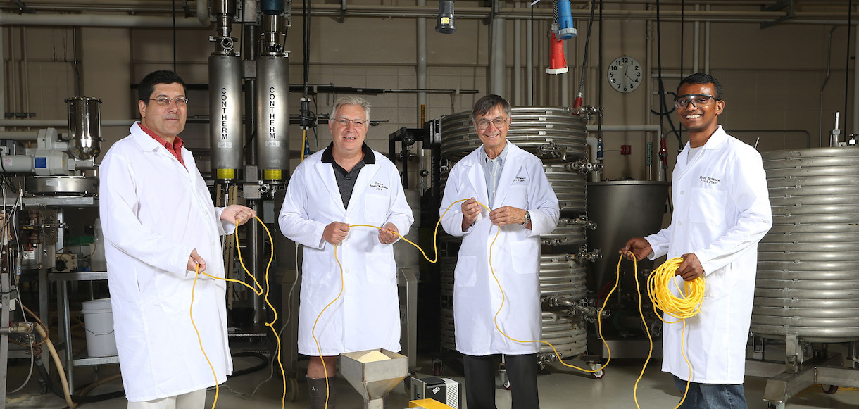 4 researchers in a lab holding a yellow rope
