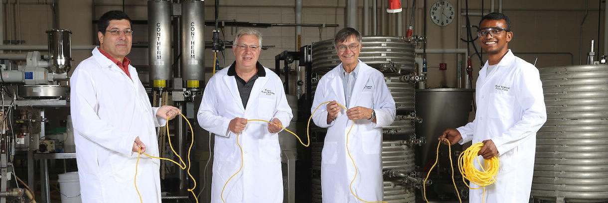 4 researchers in a lab holding a yellow rope